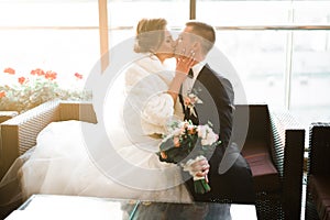 Beautiful bride and groom embracing and kissing on their wedding day