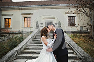 Beautiful bride and groom embracing and kissing on their wedding day