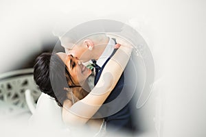 Beautiful bride and groom embracing and kissing on their wedding day