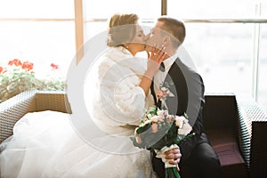 Beautiful bride and groom embracing and kissing on their wedding day