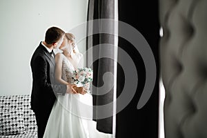 Beautiful bride and groom embracing and kissing on their wedding day