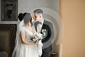 Beautiful bride and groom embracing and kissing on their wedding day