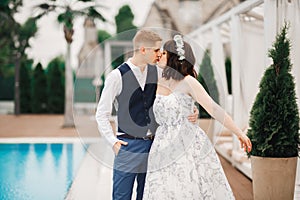 Beautiful bride and groom embracing and kissing on their wedding day