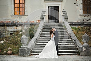 Beautiful bride and groom embracing and kissing on their wedding day