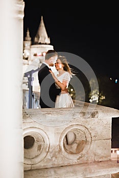 Beautiful bride and groom embracing and kissing on their wedding day outdoors