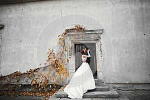 Beautiful bride and groom embracing and kissing on their wedding day outdoors