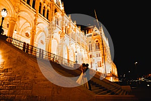 Beautiful bride and groom embracing and kissing on their wedding day outdoors