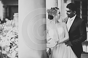 Beautiful bride and groom embracing and kissing on their wedding day outdoors