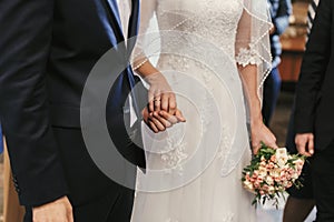 beautiful bride and groom hands exchanging wedding rings in church during wedding ceremony. spiritual holy matrimony. wedding photo