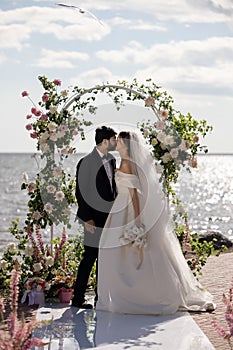 Beautiful Bride and Groom During an Outdoors Wedding Ceremony on a Beach Near the Sea. Perfect Venue