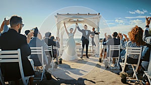 Beautiful Bride and Groom During an Outdoors Wedding Ceremony on an Ocean Beach. Perfect Venue for