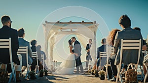 Beautiful Bride and Groom During an Outdoors Wedding Ceremony on an Ocean Beach. Perfect Venue for