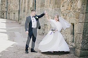 Beautiful bride and groom posing in a yard of a castle