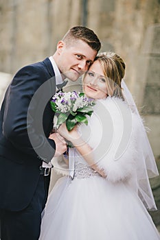 Beautiful bride and groom posing in a yard of a castle