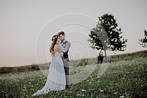 Beautiful bride and groom at sunset in green nature.