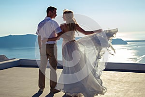 Beautiful bride and groom in their summer wedding day on greek island Santorini