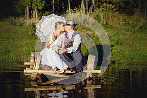 Beautiful bride and groom with umbrella on the bridge