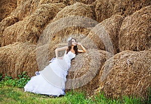 Beautiful bride in hay stack at her wedding day
