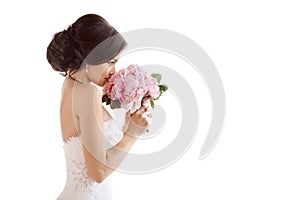 Beautiful bride with her flowers. Wedding hairstyle make-up luxury fashion dress and bouquet