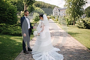 Beautiful bride with her handsome groom walking outside on theri wedding day. Happy newlyweds