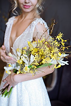 Beautiful bride is holding a wedding colorful bouquet