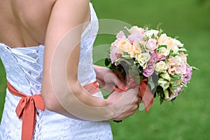 Beautiful bride is holding a wedding colorful bouquet