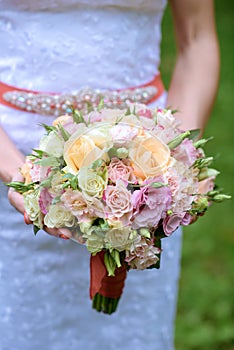 Beautiful bride is holding a wedding colorful bouquet