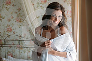 Beautiful bride in lingerie in the morning before the wedding. White negligee of the bride, preparing for the wedding