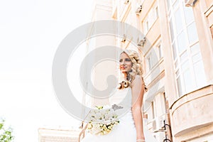 Beautiful bride in magnificent dress stands alone