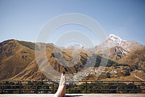 Beautiful bride in a nice dress stands on the terasse with great mountain view in Georgia