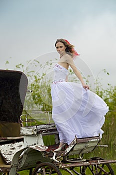 Beautiful bride and old carriage