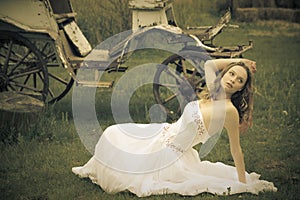 Beautiful bride and an old carriage