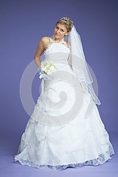 Beautiful bride poses on violet background