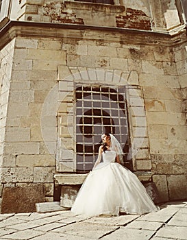Beautiful bride posing in her wedding day near the old castle