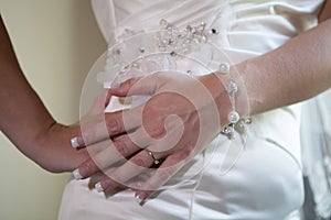 Beautiful bride's hand are on her waist