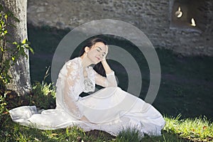 Beautiful bride sitting in grass