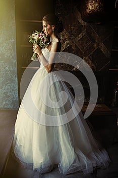 A beautiful bride is standing in a room in the window of a window