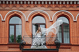 Beautiful bride standing on the stone balcony
