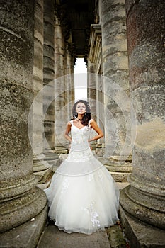 A beautiful bride stands next to the old church