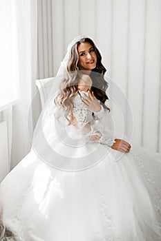 Beautiful bride wearing fashion wedding dress with feathers with luxury delight make-up and hairstyle, studio indoor