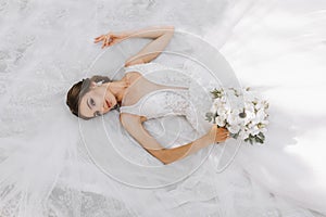 Beautiful bride with wedding bouquet of flowers, attractive woman in wedding dress