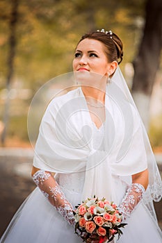 Beautiful bride in wedding dress and bridal bouquet, happy newlywed woman with wedding flowers, woman with wedding makeup and hair