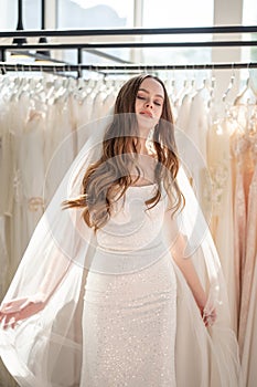 Beautiful bride in wedding dress during fitting