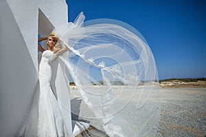 Beautiful bride in a wedding dress in greece with a long veil