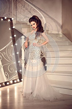 Beautiful Bride in wedding dress posing on staircase. Elegant br