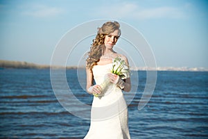 Beautiful bride in a white dress on coast of river