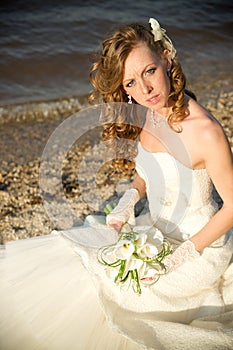 Beautiful bride in a white dress on coast of river