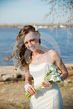 Beautiful bride in a white dress on coast of river