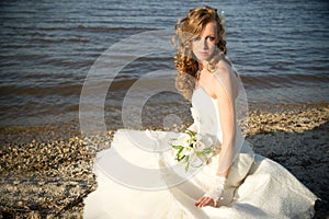 Beautiful bride in a white dress on coast of river