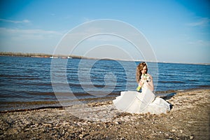 Beautiful bride in a white dress on coast of river